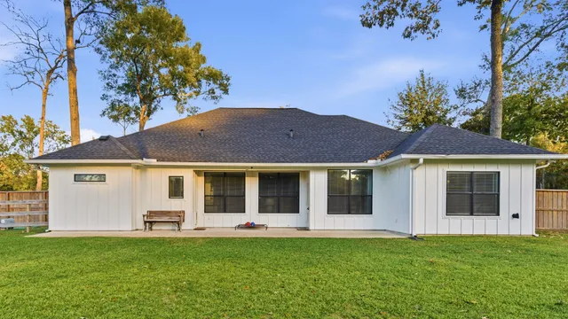 a view of a yard in front of a house with a large tree