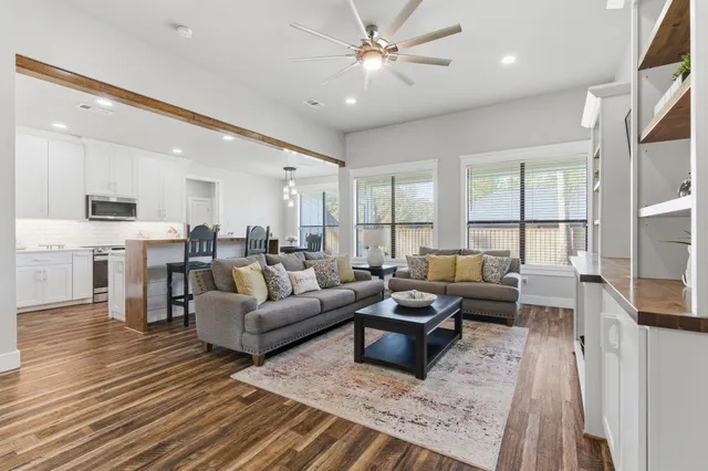 a living room with lots of furniture and kitchen view