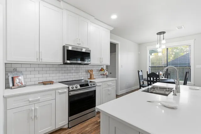 a kitchen with a sink a stove and cabinets