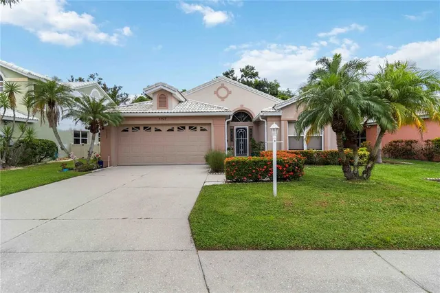 a view of a white house with a big yard and palm trees
