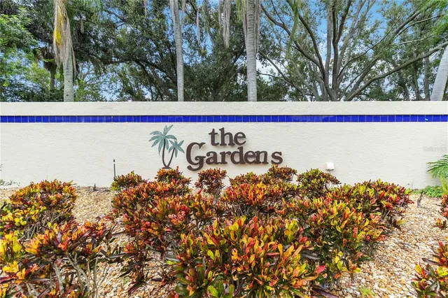 an empty room with wooden floor chandelier fan and windows