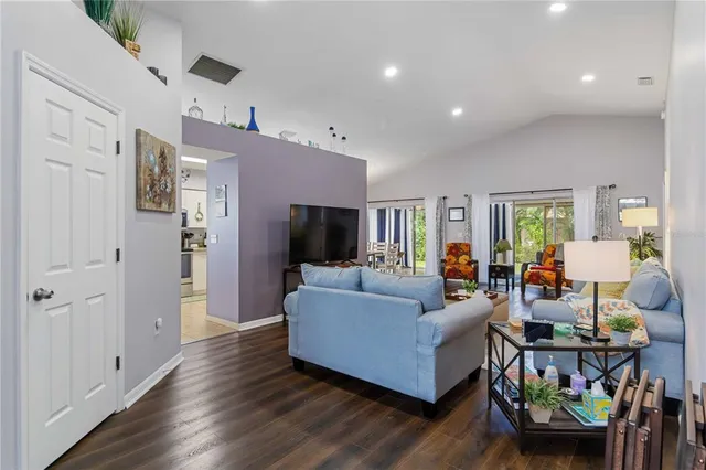 a living room with furniture and a wooden floor