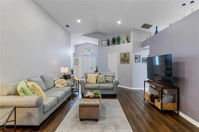 a living room with furniture and wooden floor