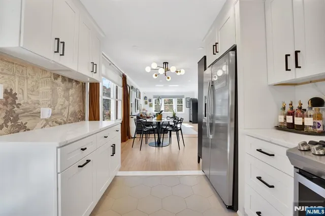 a kitchen with white cabinets and stainless steel appliances
