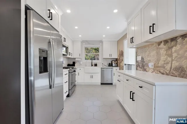 a kitchen with white cabinets and stainless steel appliances