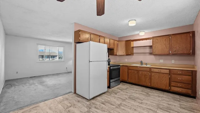 a kitchen with granite countertop a refrigerator and a sink