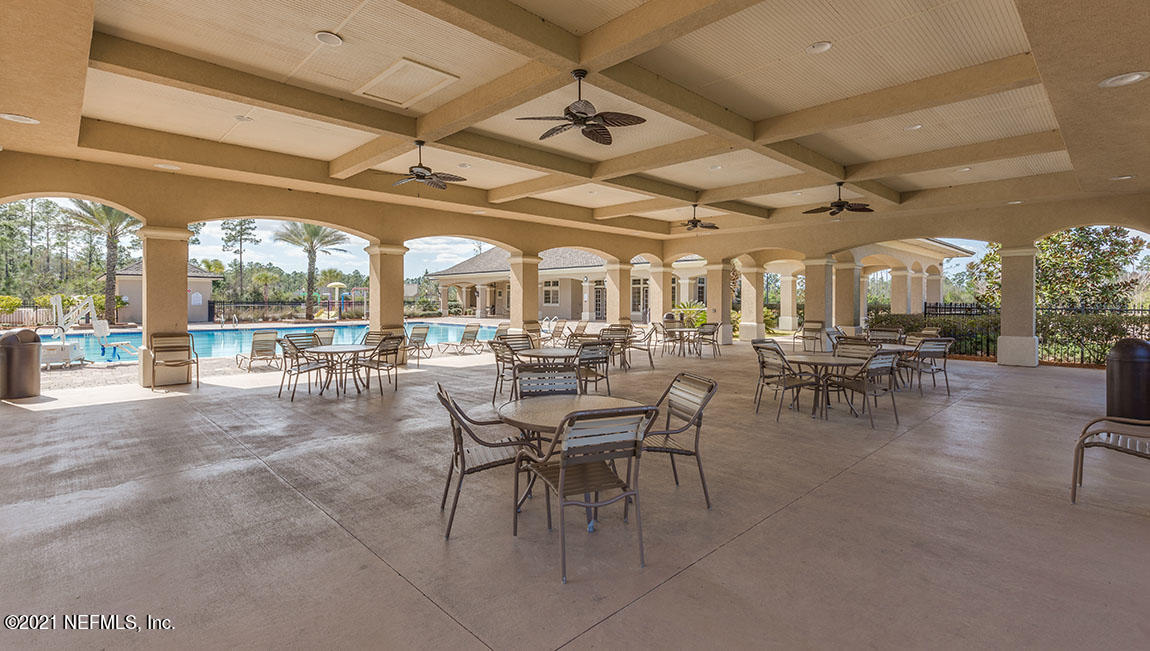 65461 Crested Heron Yulee, FL 32097 - Photo 5 of 14 a outdoor space with lots of white furniture a chandelier and a glass door