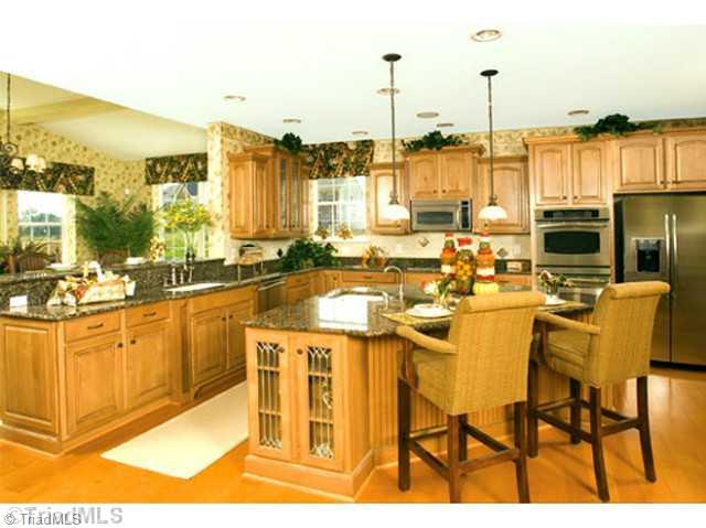 3160 Cranberry Ridge Drive High Point, NC 27265 - Photo 4 of 4 Kitchen. This Kitchen is unbelievable. Large Triangular Island with a sink located on the island. Gourmet Kitchen with gas cook-top, double ovens, microwave, disposal, wine cooler & additional compact refrigerator. Granite Tops & additional cabinetry.