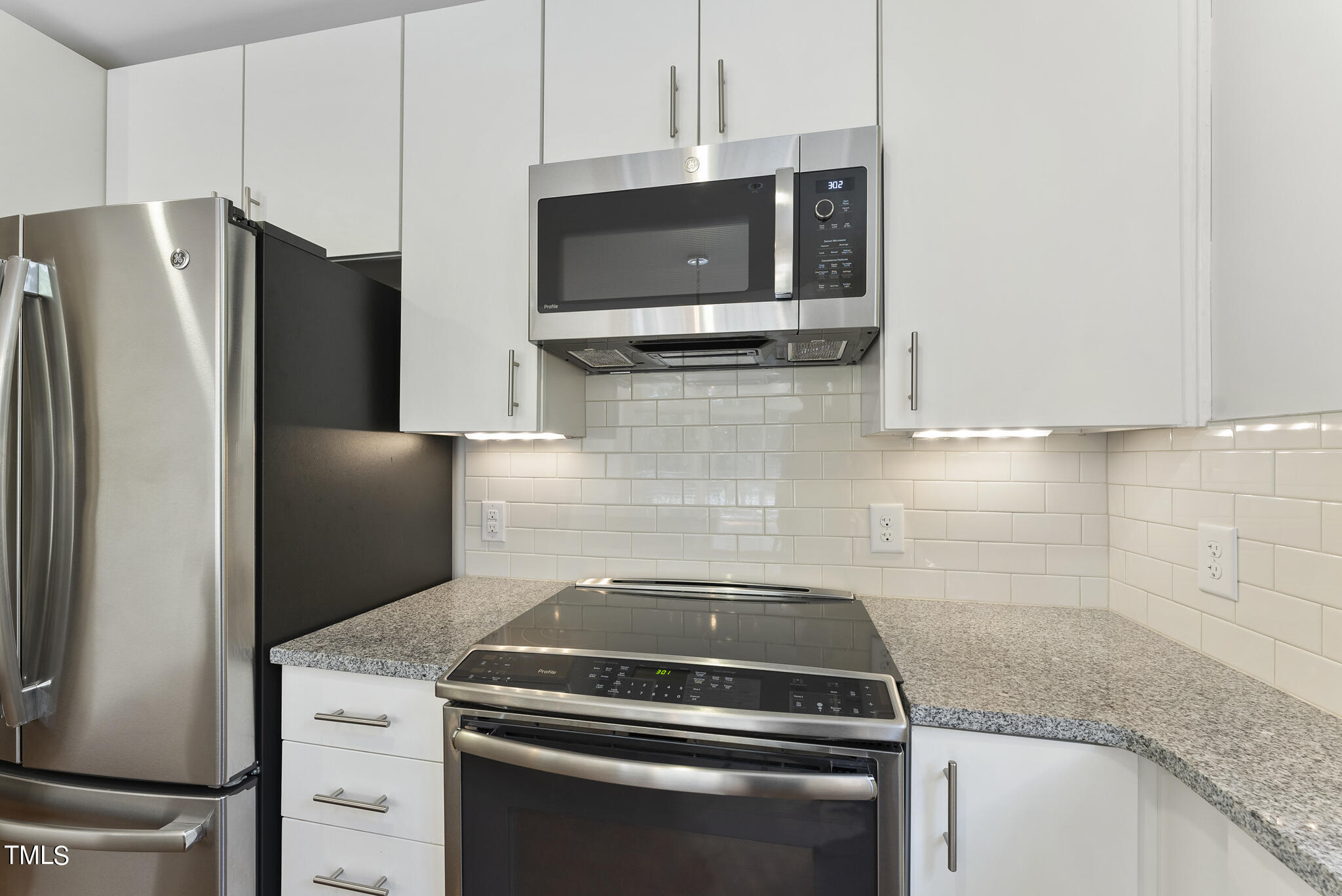 1300 St Marys Street, Unit 301 Raleigh, NC 27605 - Photo 11 of 27 a kitchen with stainless steel appliances a refrigerator stove and microwave