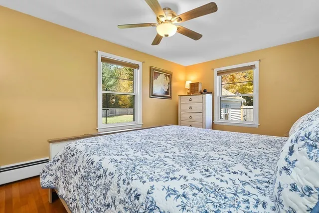 a bedroom with a bed and a dresser next to a window