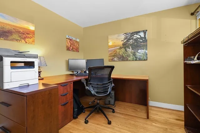 a view of a workspace with furniture and wooden floor