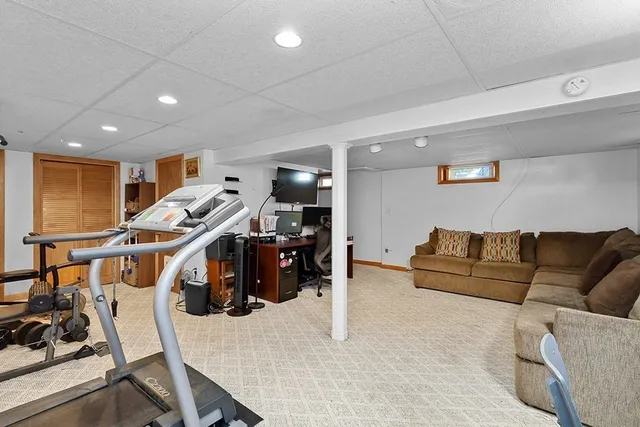 a living room with furniture a air conditioner and a window