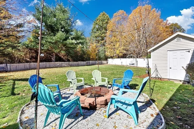 a view of a chairs and table in the backyard