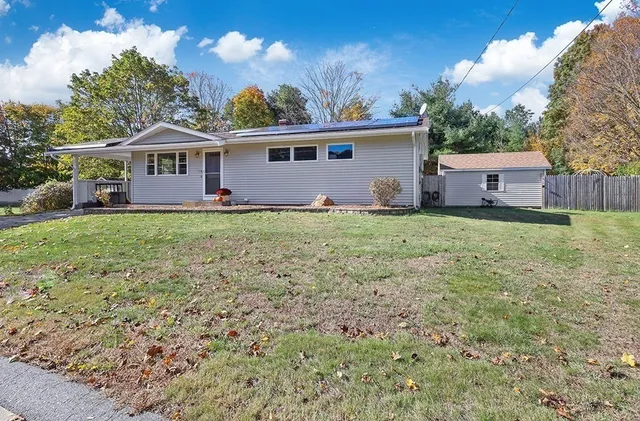 a front view of a house with yard and trees
