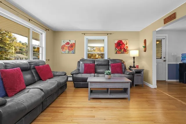 a living room with furniture large window and wall painting