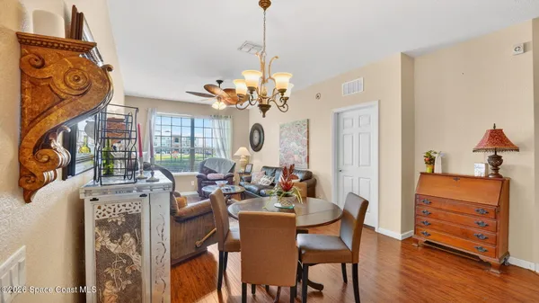 a living room with furniture a chandelier and a large mirror