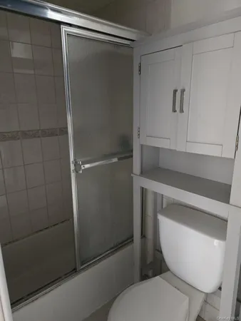 a white toilet sitting next to a shower