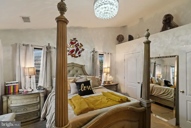 a bedroom with bed and a chandelier