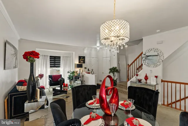 a kitchen with stainless steel appliances a sink dishwasher a refrigerator a stove a dining table and chairs with wooden floor