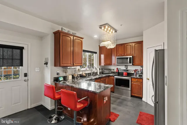 a kitchen with kitchen island granite countertop a refrigerator stove and sink