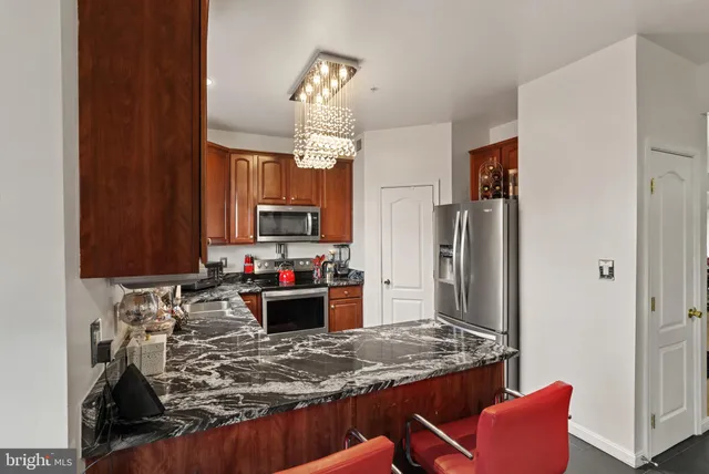 a kitchen with kitchen island granite countertop a refrigerator stove and sink