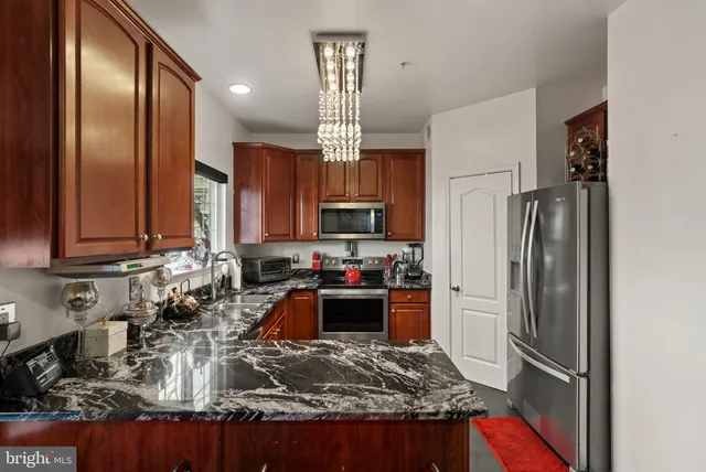 a kitchen with kitchen island granite countertop a sink stove and refrigerator