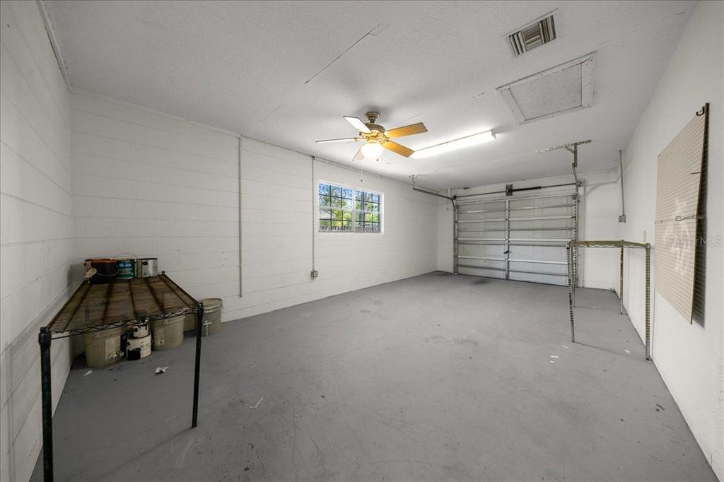 14906 Southwest 38th Circle Ocala, FL 34473 - Photo 19 of 24 a view of a garage room and a ceiling fan