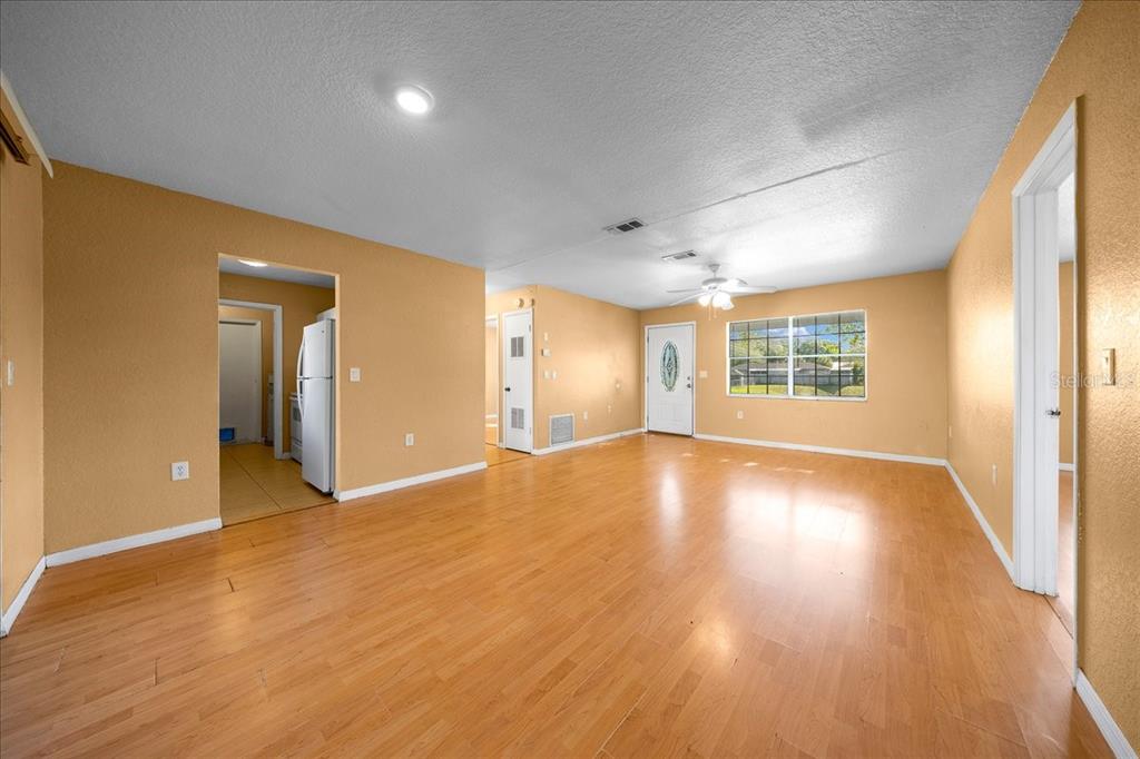 14906 Southwest 38th Circle Ocala, FL 34473 - Photo 3 of 24 a view of an empty room with wooden floor and a window