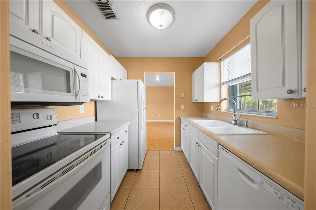 14906 Southwest 38th Circle Ocala, FL 34473 - Photo 6 of 24 a kitchen with a sink stove and microwave