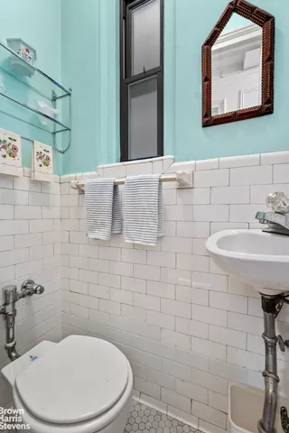 a bathroom with a toilet sink and mirror
