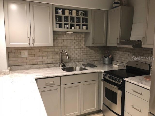 2625 South Atlantic Avenue, Unit 4 Cocoa Beach, FL 32931 - Photo 11 of 14 a kitchen with stainless steel appliances granite countertop a sink stove and cabinets