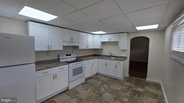 a kitchen with granite countertop white cabinets and stainless steel appliances