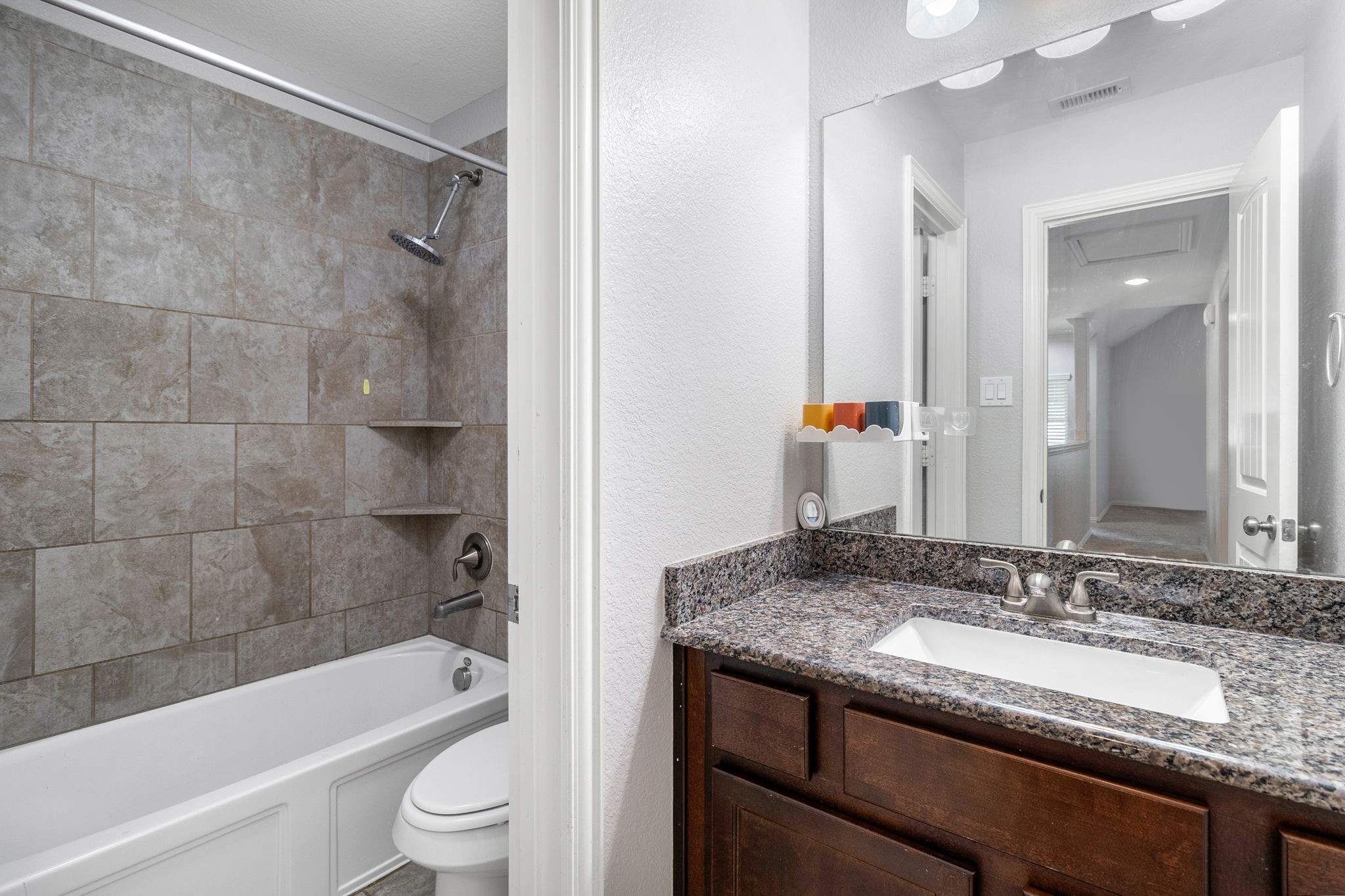 9014 San Saba Way Willis, TX 77378 - Photo 15 of 18 a bathroom with a granite countertop bathtub shower sink vanity and toilet