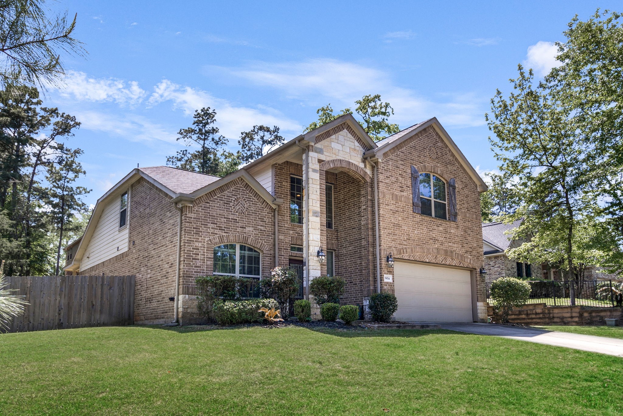 9014 San Saba Way Willis, TX 77378 - Photo 2 of 18 a front view of a house with a garden and yard