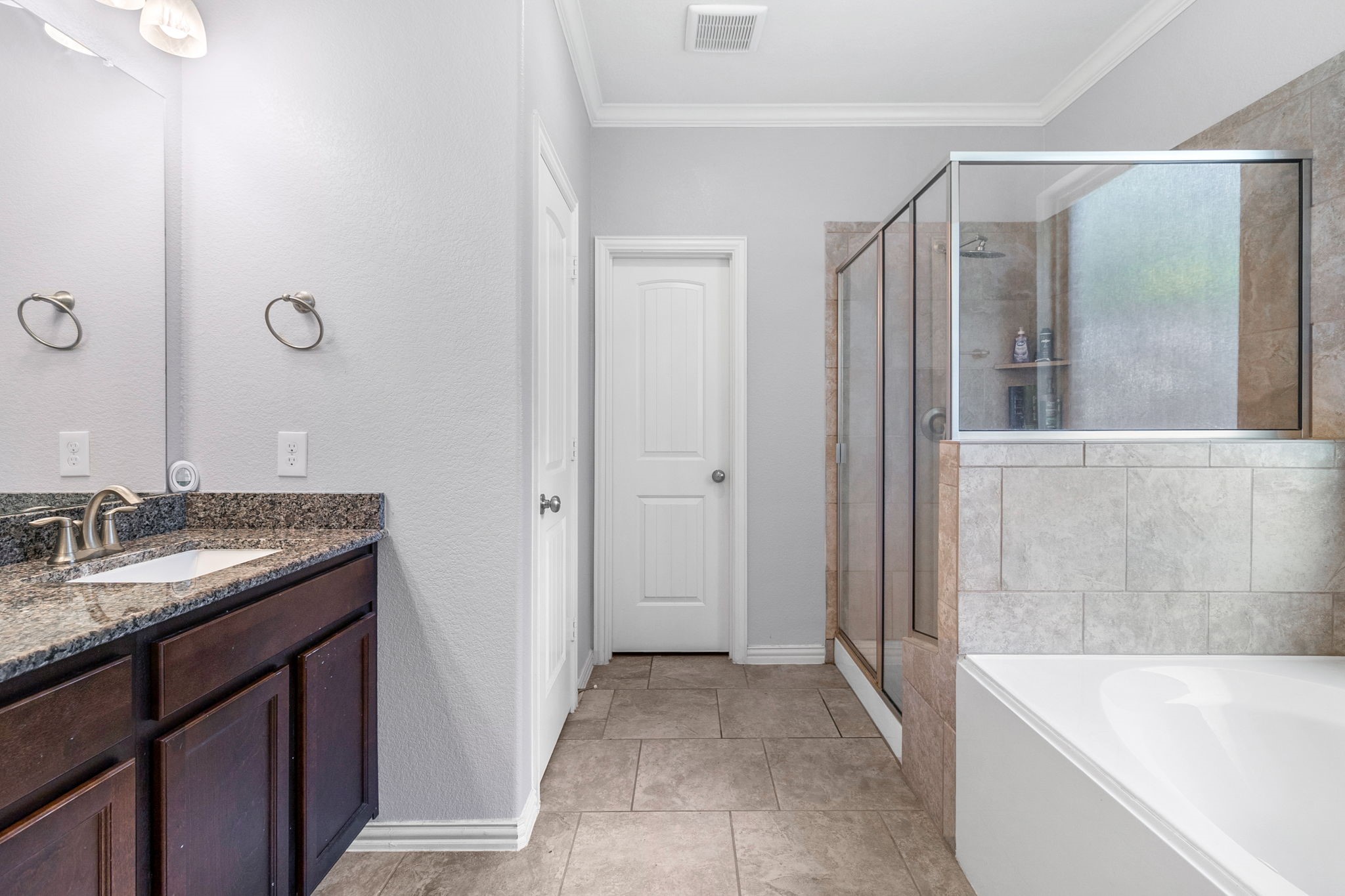 9014 San Saba Way Willis, TX 77378 - Photo 9 of 18 a bathroom with a granite countertop bathtub shower sink and mirror