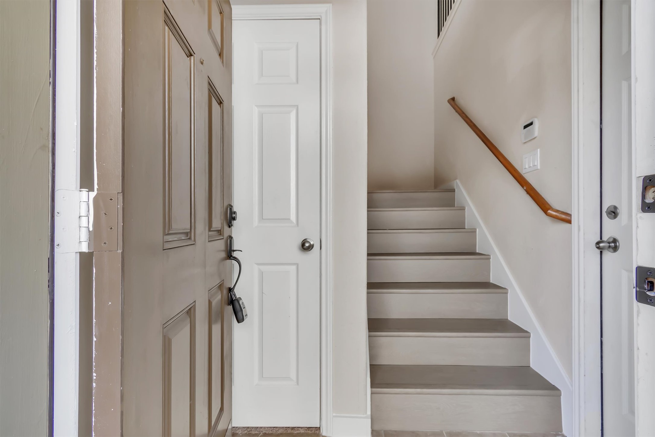 14815 Avery Ranch Boulevard, Unit 2A Austin, TX 78717 - Photo 8 of 27 Upon entry, a welcoming staircase ascends gracefully, hinting at the living spaces above.