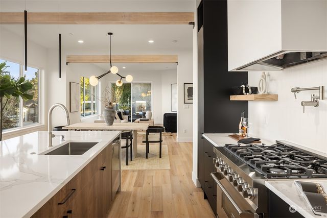 a kitchen with stainless steel appliances granite countertop a stove a sink and a wooden floors