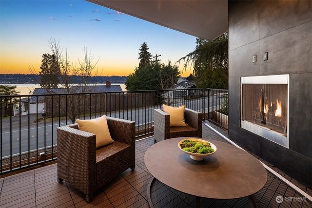 a view of a roof deck with dining and a garden