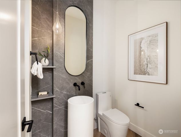 a bathroom with a toilet a sink and mirror