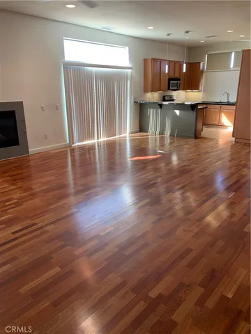 a kitchen with stainless steel appliances wooden floor dining table and chairs