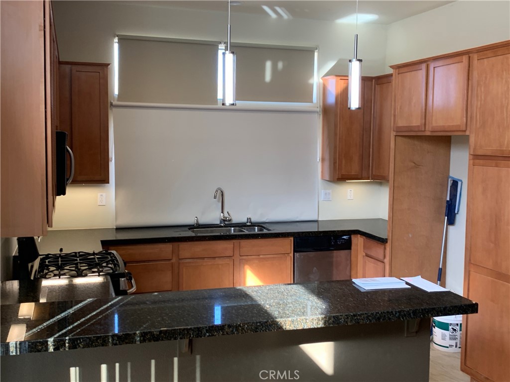 60055 Overture Drive Palm Springs, CA 92262 - Photo 17 of 19 a kitchen with stainless steel appliances granite countertop a sink stove and refrigerator