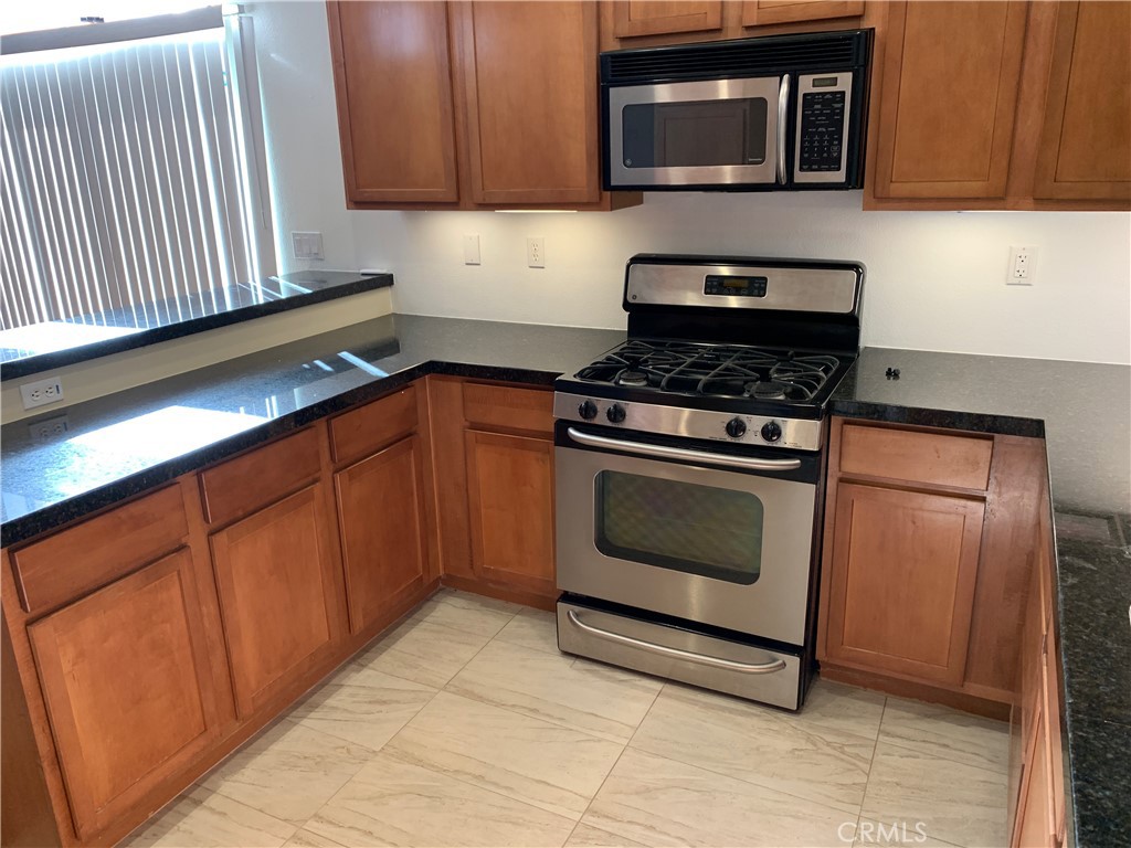 60055 Overture Drive Palm Springs, CA 92262 - Photo 18 of 19 a kitchen with granite countertop cabinets stove and microwave