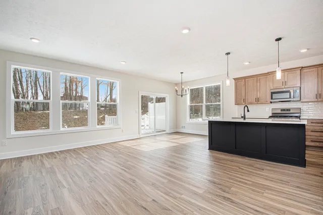 a large kitchen with wooden floors and stainless steel appliances