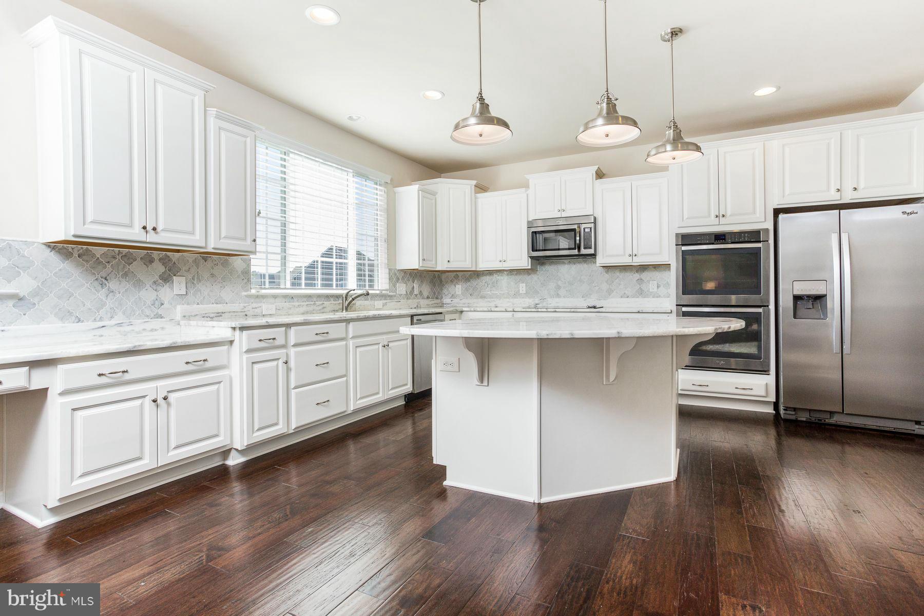 23 Tankard Road Stafford, VA 22554 - Photo 2 of 29 a kitchen with stainless steel appliances granite countertop a stove a sink dishwasher a refrigerator white cabinets and wooden floor