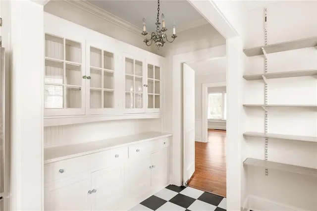 a hallway with windows and chandelier
