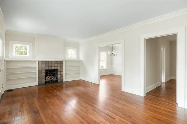 an empty room with a fireplace and wooden floor