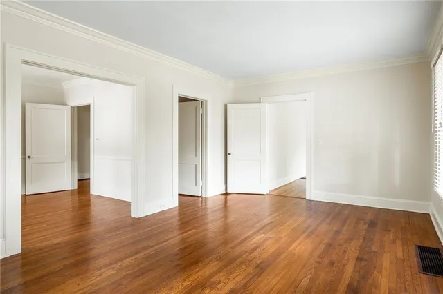 a view of an empty room with wooden floor