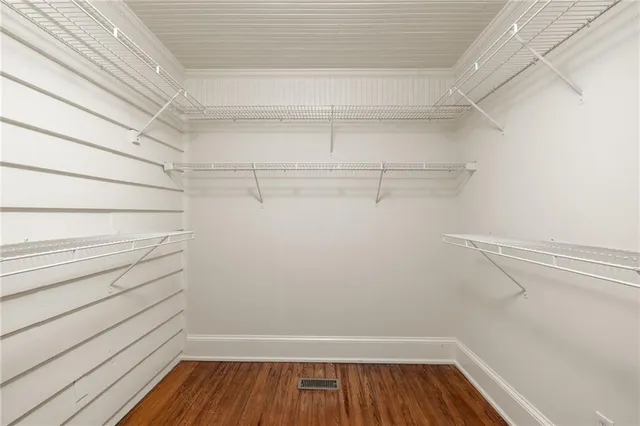 a view of walk in closet with empty racks