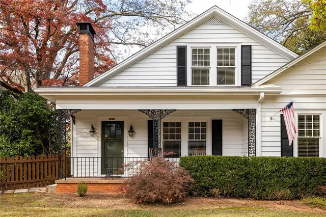 a view of a white house with large windows and a large tree