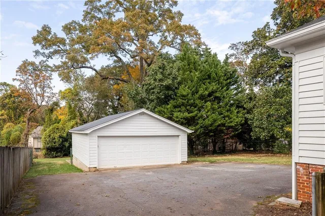 a view of a house with a yard and large tree